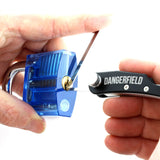 Dangerfield Skeleton Key EDC tool lock picking a clear blue practice padlock. Tip is inside the padlock